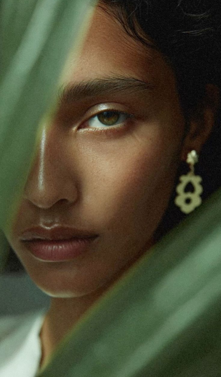 Close-up portrait of a woman surrounded by tropical greenery