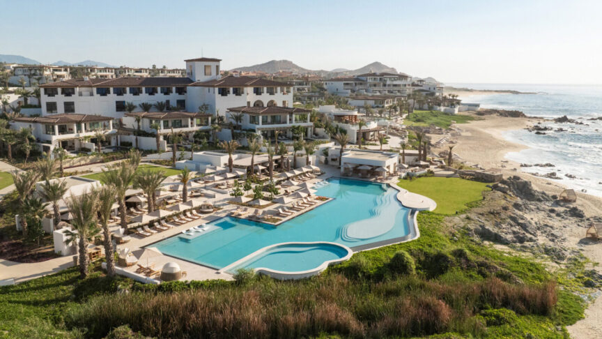 Oceanfront pool and hacienda-style buildings at Four Seasons Resort Cabo Del Sol, beside a sandy beach in Los Cabos.